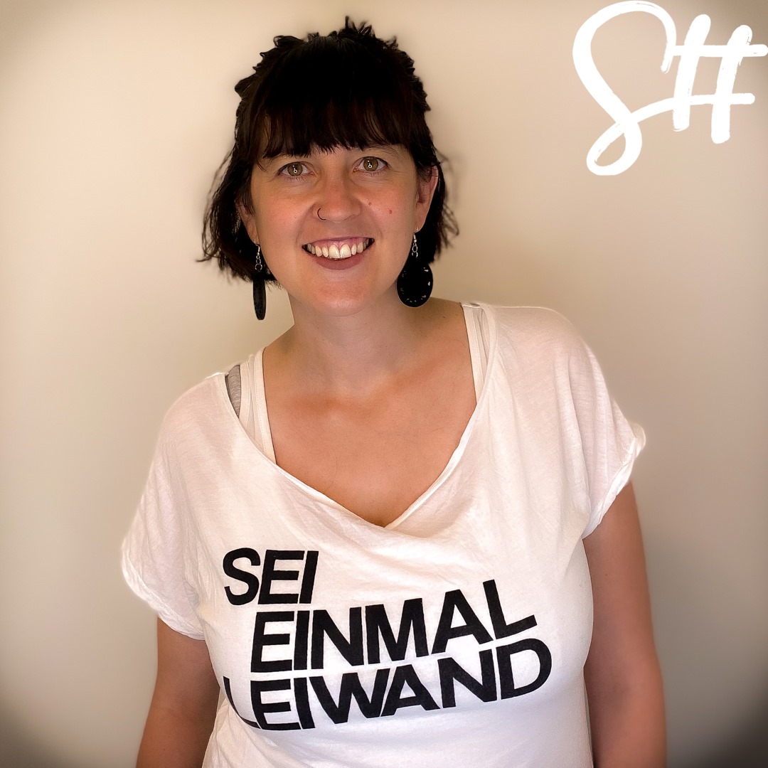 Frau trägt weißes T-Shirt mit Aufschrift Sei einmal leiwand