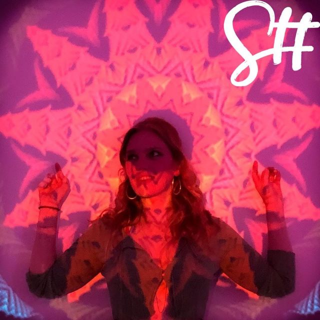 Frau steht vor buntem Hintergrund