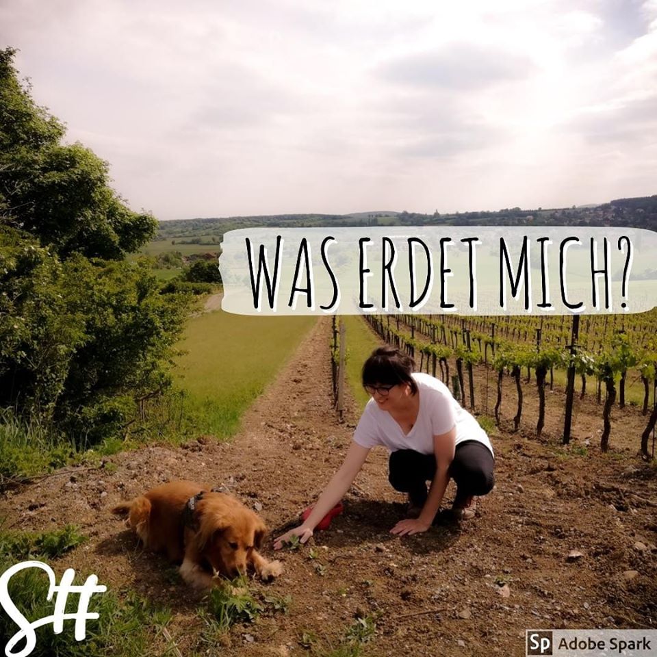 Frau mit Hund kniet am Weinberg