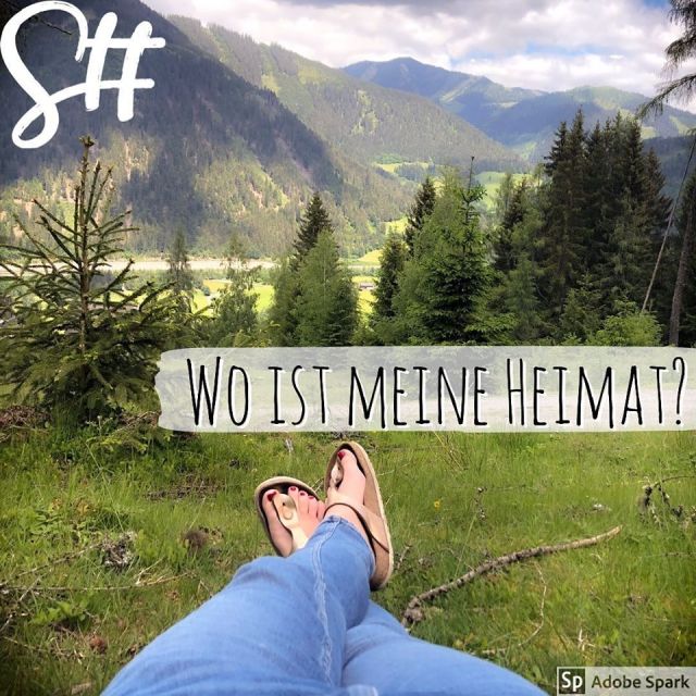 Beine und Füße mit Birkenstock Gizeh goldfarben vor der Berglandschaft