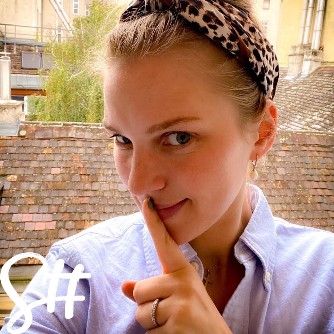 Frau macht mit dem Finger das Schweigesymbol